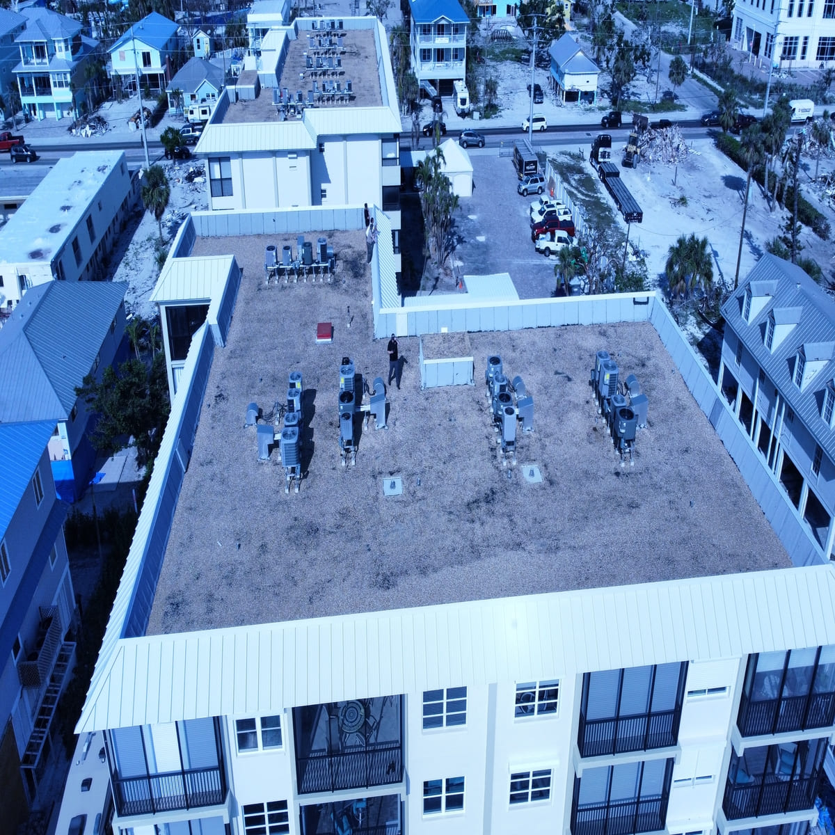 Commercial roofing project showing flat roof installation with HVAC units on multi-story building in Denver
